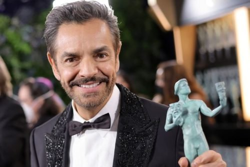 Eugenio Derbez holding a SAG Award and smiling at an event.