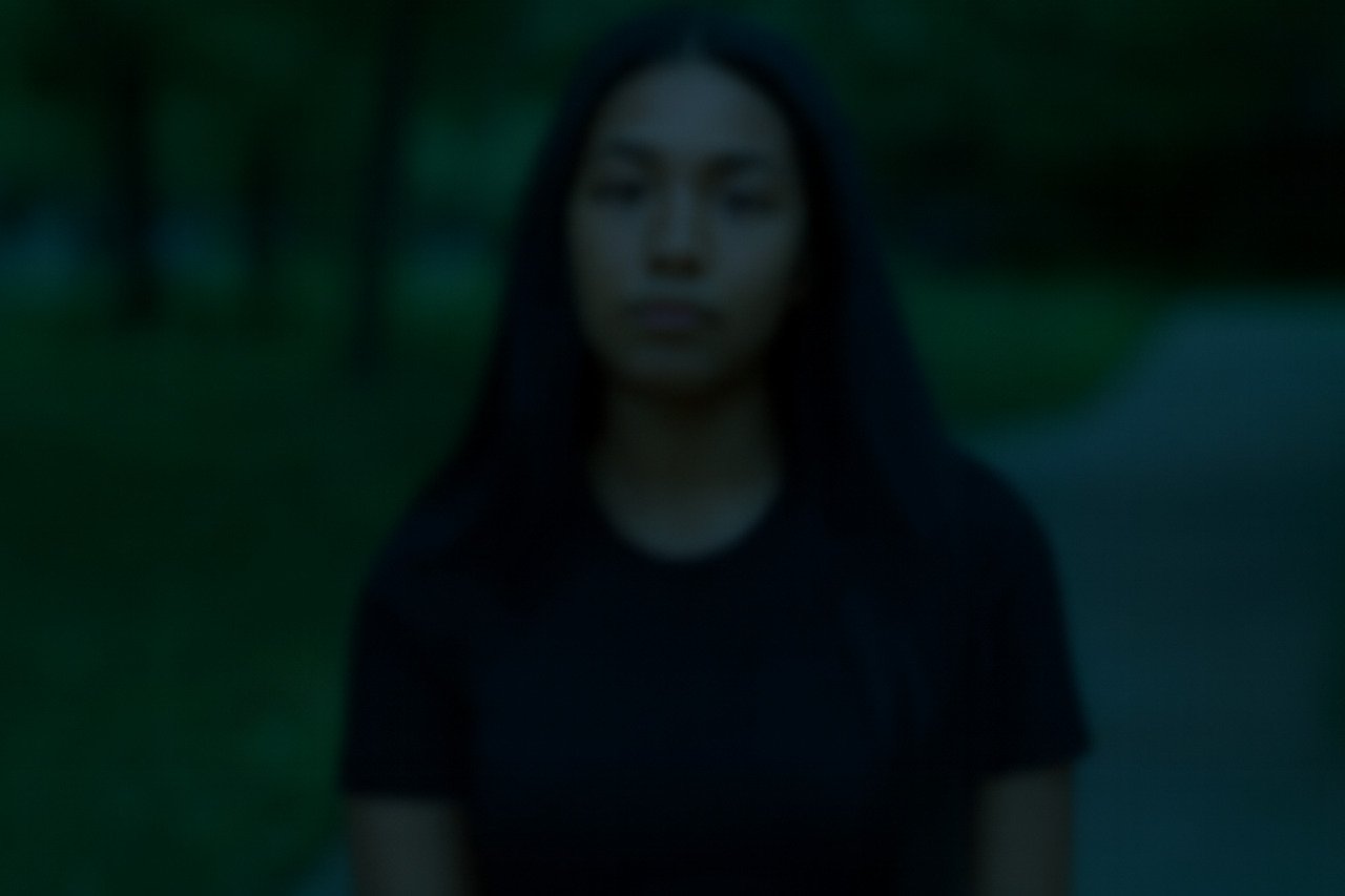 Blurred outdoor portrait of a young woman.