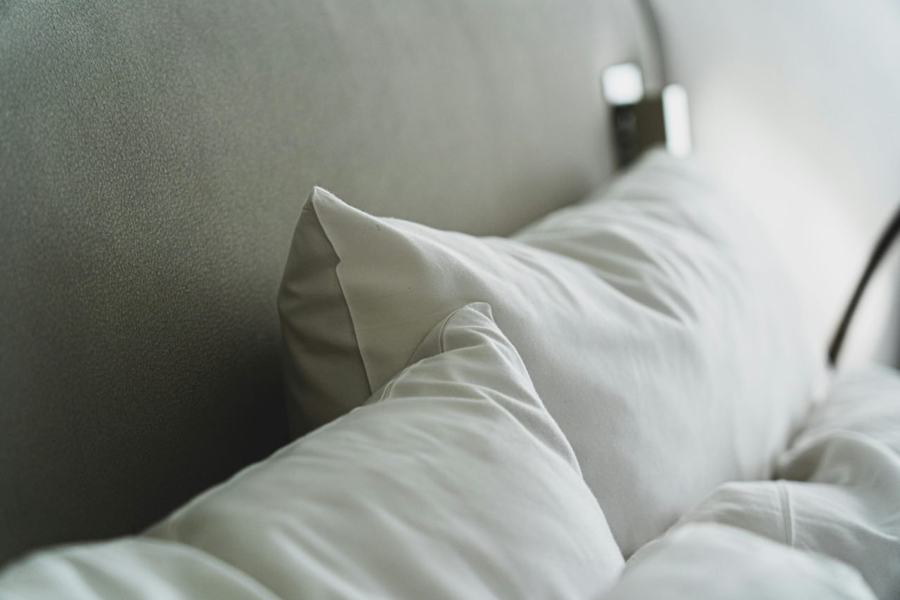 Close-up of white pillows and a duvet on a neatly made bed.
