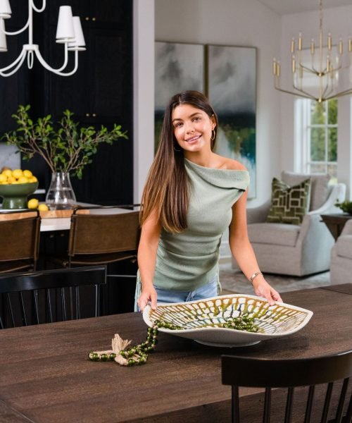 Hannah Ann Sluss decorating a dining table in a modern, stylish home interior.