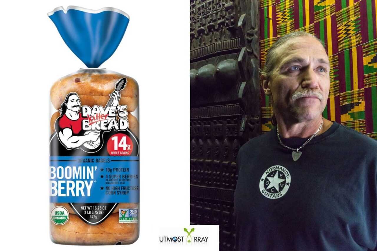 A split image showing a package of Dave’s Killer Bread “Boomin’ Berry” organic bagels on the left and Dave Dahl standing indoors on the right. The bagel packaging features a cartoon image of a muscular man with a guitar and bold text highlighting 14g whole grains and organic ingredients. On the right, a man with light hair, a mustache, and a chain necklace stands against a colorful patterned background, wearing a dark shirt with a guitar logo.