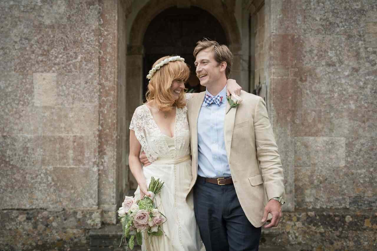 Kelly Reilly and her husband enjoying a joyful moment outdoors, captured in a romantic, candid photo