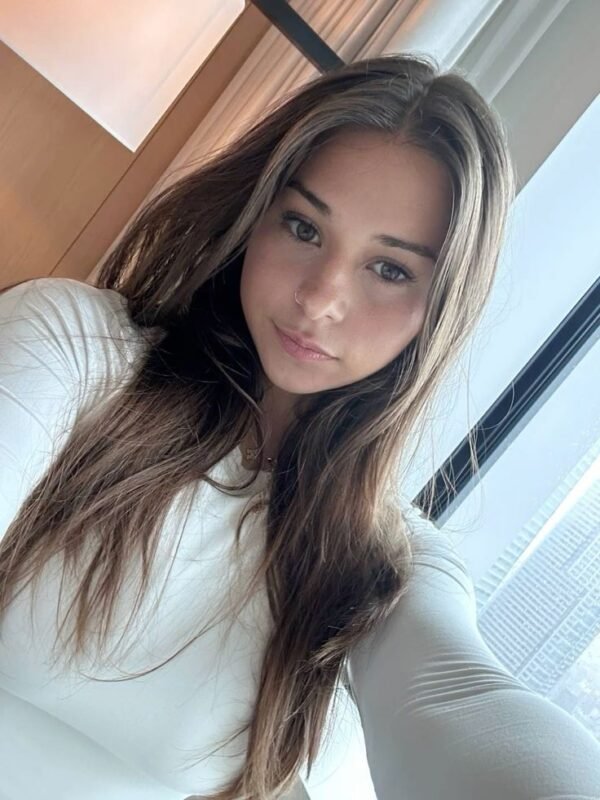 Young woman taking a selfie indoors near a window with natural light